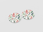 Pair of round earrings with leaf pattern on a light gray background