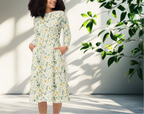Woman wearing a floral dress standing in a bright room with sunlight casting shadows.