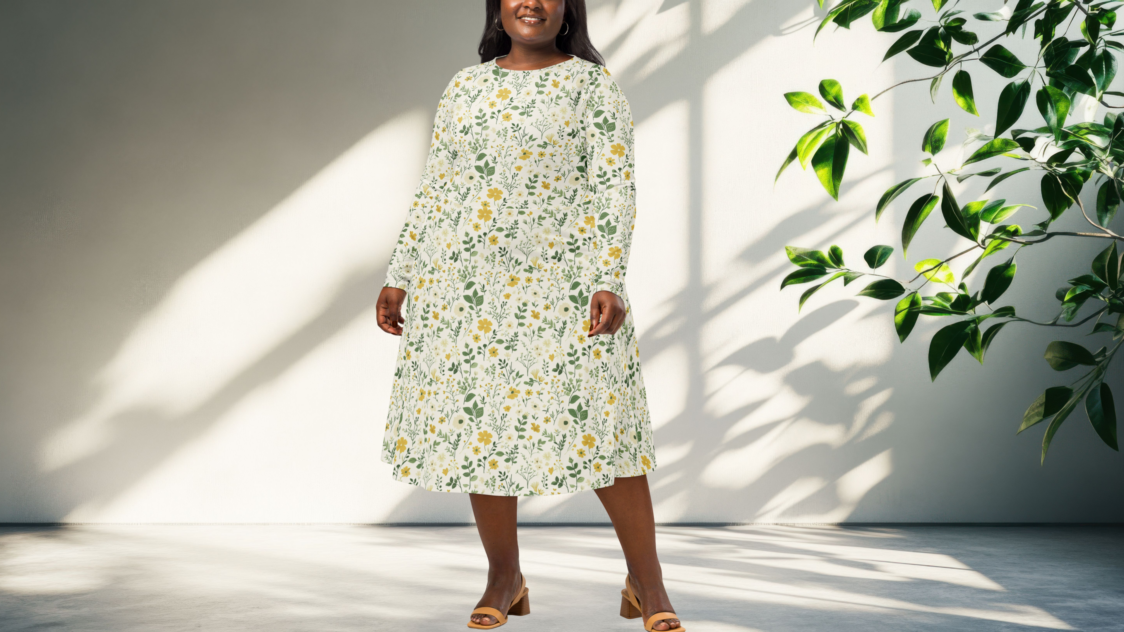 Woman wearing a floral dress standing in a bright room with a plant.