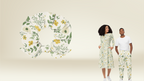 Two people wearing matching floral outfits with a large floral design on a beige background.