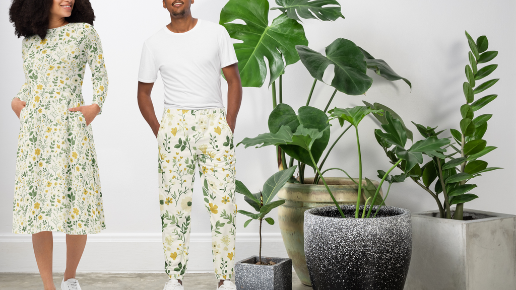 Two people wearing matching floral outfits standing in a room with potted plants.