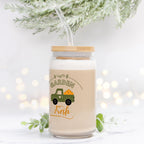 Jar with lid and straw, featuring a truck and 'Garden Fresh' text, on a white background with blurred lights and greenery.