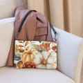 Floral-patterned bag with a brown leather jacket on a beige couch