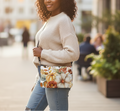 Woman holding a floral-patterned handbag on a city street