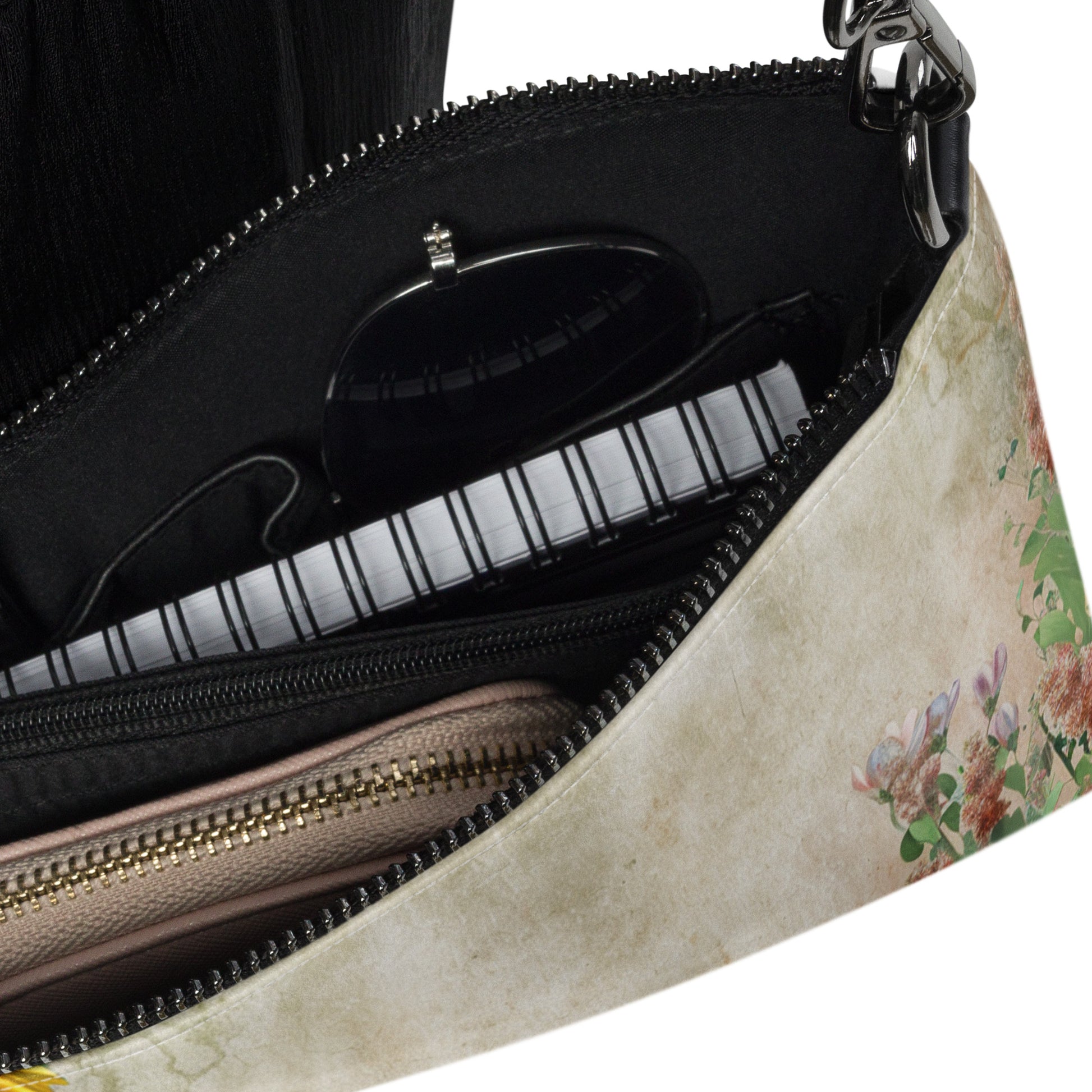 Floral-patterned handbag with a zipper partially open, revealing a black interior.