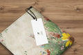 Floral-patterned product with a white tag featuring a logo on a white background