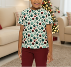 Young girl wearing a patterned shirt in a living room with a Christmas tree.