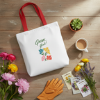 White tote bag with floral design and text on a wooden surface with flowers, coffee, and gardening gloves.