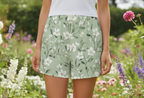 Person wearing floral shorts in a garden setting