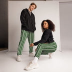 Two people wearing matching green and white striped pants on a plain background