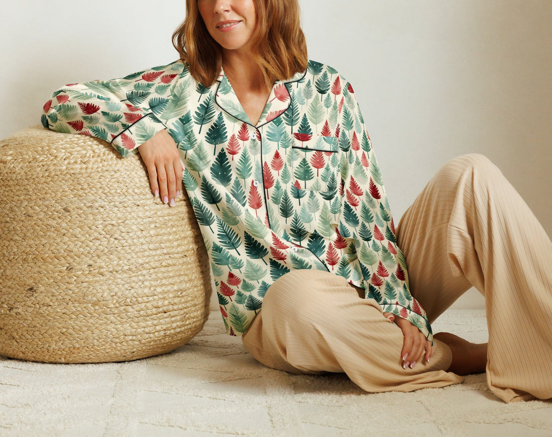 Person in festive pajamas sitting on a couch with Christmas presents and decorations.