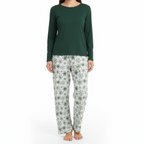 Person wearing a green long-sleeve top and floral pajama pants on a white background