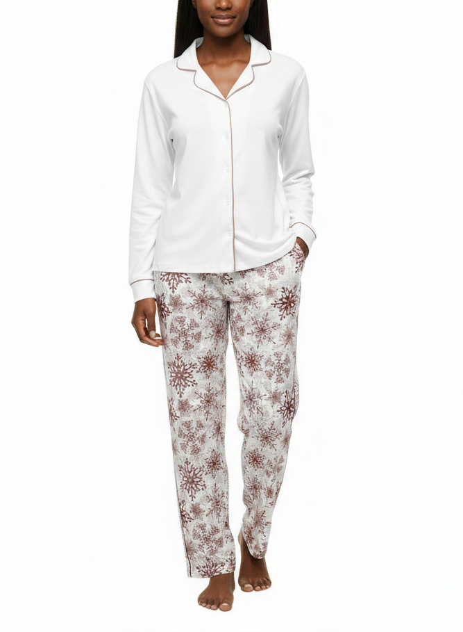 Woman wearing a white long-sleeve top and patterned pants on a white background