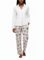 Woman wearing a white long-sleeve top and patterned pants on a white background