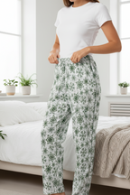 Person wearing white t-shirt and floral pants in a bedroom setting