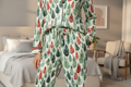 Person wearing a leaf-patterned pajama set in a bedroom.