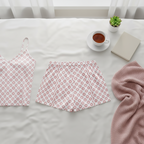 Floral-patterned top and skirt on a bed with a cup of tea and plant in the background
