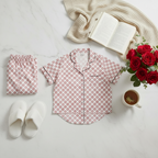 Floral pajama set with slippers, book, and coffee on a marble surface