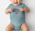 Baby wearing a light blue onesie with 'Baby Gardener' text and tomato graphics on a white background