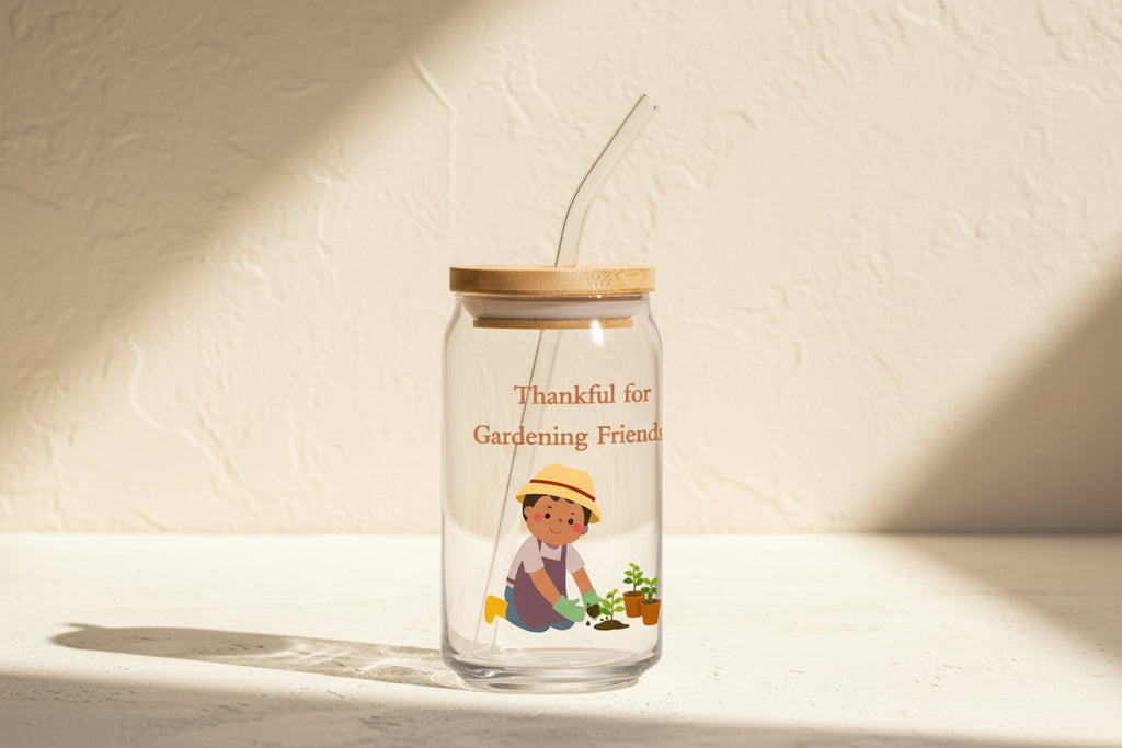 Glass tumbler with straw featuring a gardening-themed design and text on a white background
