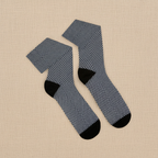 Pair of blue checkered socks with black toes and cuffs on a beige fabric background