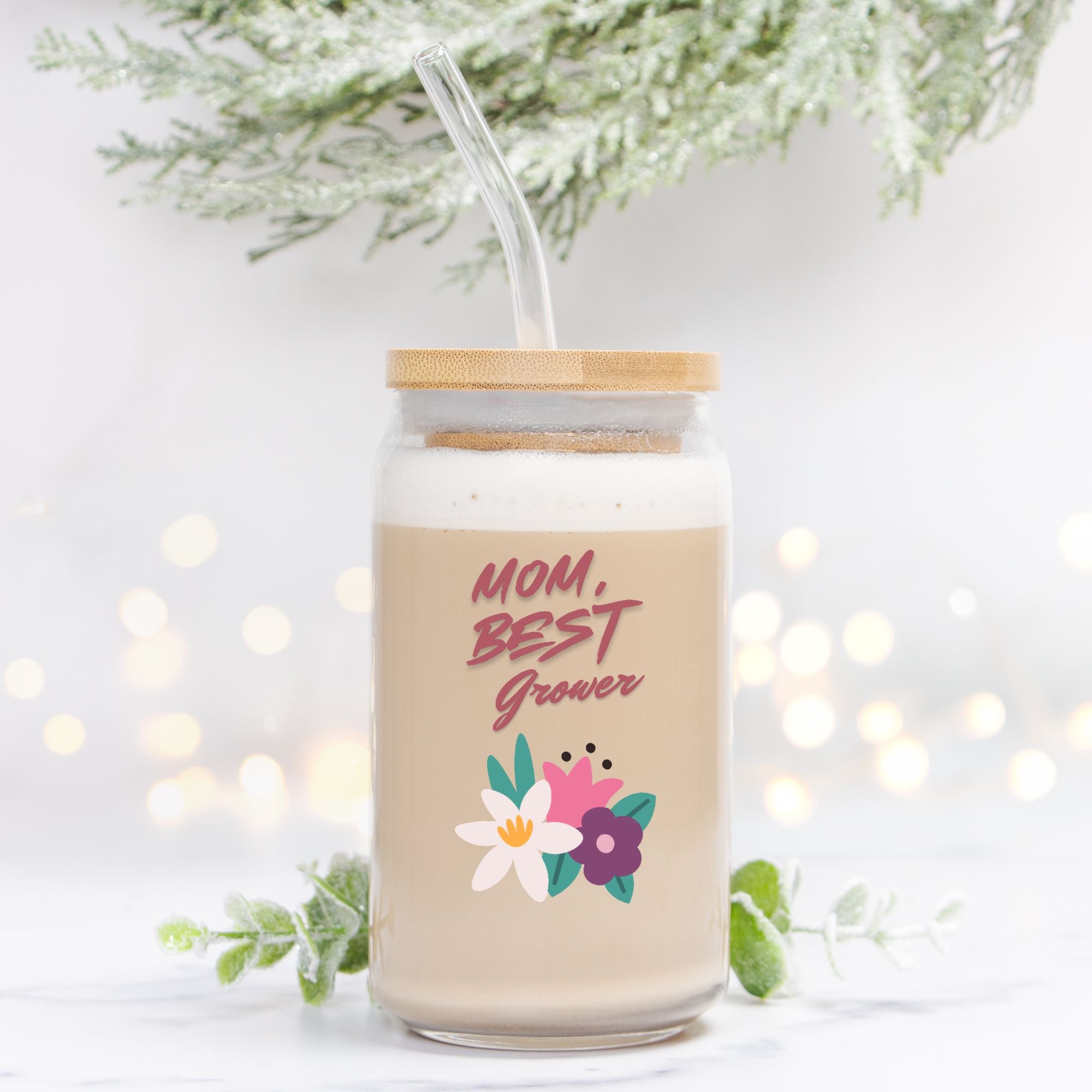 Glass tumbler with straw and floral design, featuring text 'Mom, Best Grower' on a light background.