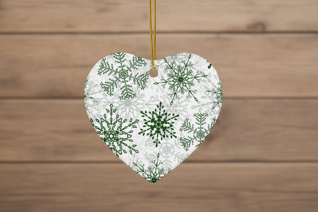 Heart-shaped ornament with green snowflake pattern on a wooden background