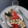 Floral-patterned napkin on a table setting with cutlery and glass.