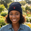 Woman wearing a navy beanie with embroidery in an outdoor setting