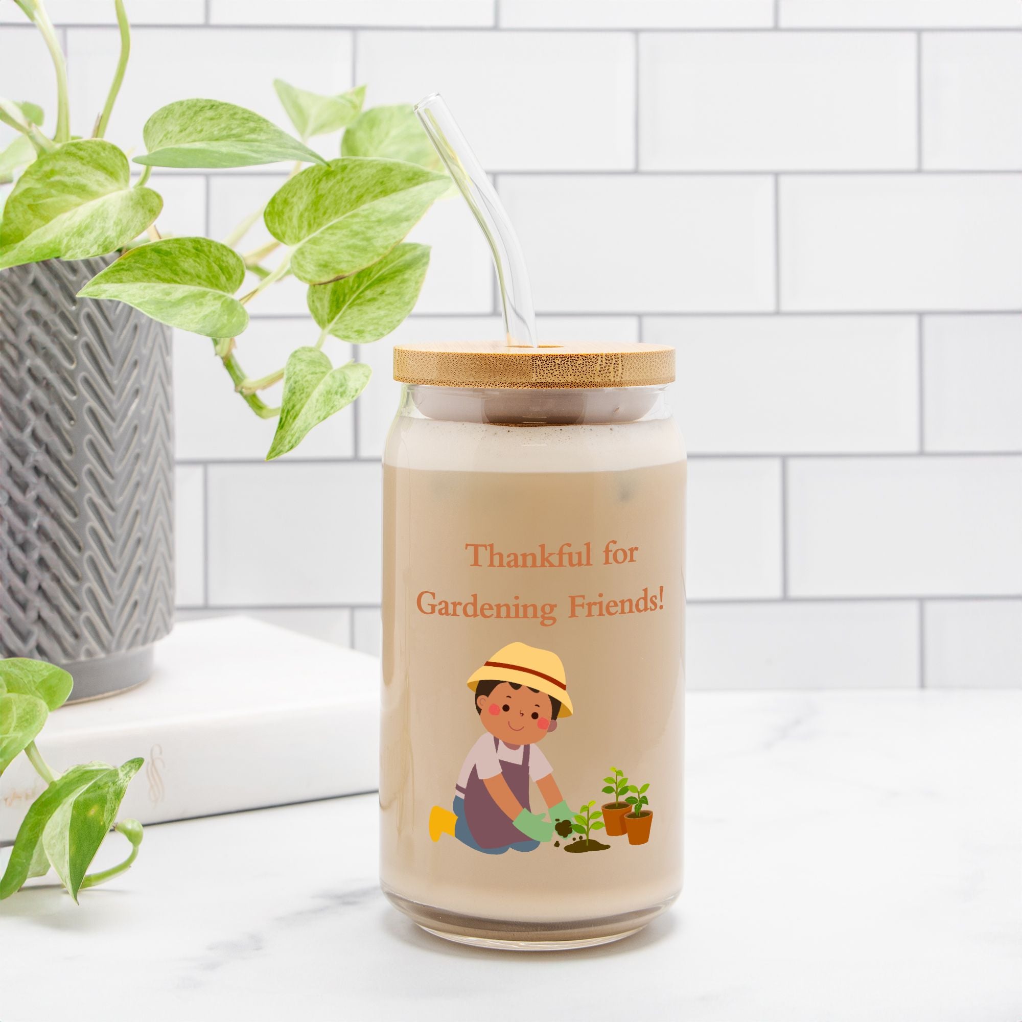 Jar with a cartoon character and text 'Thankful for Gardening Friends!' on a white surface with plants.