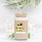 Jar with a lid and straw, featuring an illustration of two people gardening, on a white background with blurred lights and greenery.