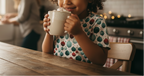 Child drinking from a mug in a kitchen setting