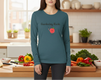 Person wearing a teal long-sleeve shirt with 'Gardening Rocks' text and tomato graphic in a kitchen.