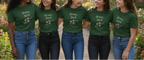 Five women wearing green t-shirts with 'Grow, Girl!' text and floral graphics.