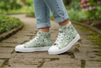 Green floral high-top sneakers worn on a stone path with a garden background