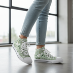 Green floral sneakers worn with light blue jeans indoors.