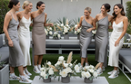 Group of women posing together with floral arrangements outdoors.