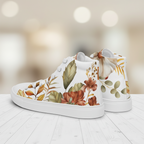 White high-top sneakers with floral design on a light wooden floor.