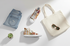 Denim jacket, floral sneakers, tote bag with sunglasses, and decorative plate on a white surface