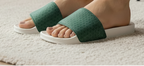 Person wearing green slide sandals in a living room setting